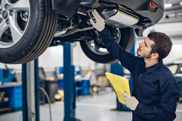 Auto car repair service center. Mechanic examining car